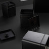 Set of black metal kitchen storage tins with lids, shown on dark surface