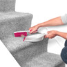 Pink-handled brush sweeping carpeted stairs into matching dustpan