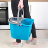 Blue plastic mop bucket with grey handle, shown carried in a modern kitchen
