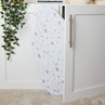 White ironing board with pastel terrazzo cover stored upright in cupboard