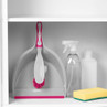 Set of cleaning items including pink and white dustpan and brush, spray bottle, sponge, and bottle in cupboard