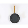 Non-stick frying pan with gold handle on white background