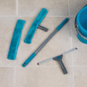 Blue and grey window cleaning set including squeegee, microfibre pads and bucket on tiled floor