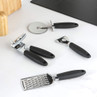 Set of four stainless steel kitchen tools with black handles on a white worktop