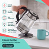 Glass kettle pouring hot water into a mug