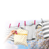 Hand placing pink peg in patterned white peg bag, baby clothes on washing line