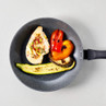 Non-stick frying pan with cooked chicken breast, grilled courgette, aubergine, and orange pepper.