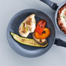 Non-stick frying pan with grilled chicken breast and roasted vegetables.