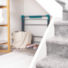 Foldable clothes airer stored under stairs in modern hallway