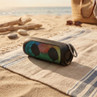 Portable Bluetooth speaker with multicolour lights on beach mat outdoors