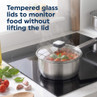 Stainless steel saucepan with tempered glass lid cooking tomato-based dish on hob.
