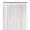 White striped shower curtain hanging on chrome rings