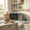 Sage green microwave with wooden handle on kitchen worktop, loaf of bread in foreground