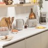 Taupe kettle, toaster and coffee machine set on kitchen counter with eggs and bread
