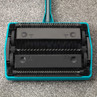 Blue manual carpet sweeper underside showing rotating brushes and mechanism