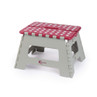 Folding grey plastic step stool with red polka dot top, side view