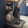 Black baking tray placed in dishwasher lower rack