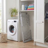 Silver folding laundry drying rack stored in utility room beside washing machine