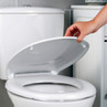 White soft close toilet seat being lowered by hand