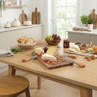 Table set with cheese board, crackers, grapes and chutney in bright modern kitchen