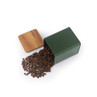 Green storage tin with wooden lid, open and spilling coffee beans