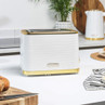 White and gold two-slice toaster on kitchen counter, modern ribbed design.