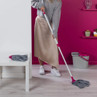 Grey and pink mop in use with matching mop head, shown with mop bucket in home setting