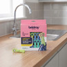 Box of 24 dual-grip pegs in pastel green and blue, shown on kitchen counter