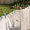 Clothes pegs holding white shirt, striped sock and towel on washing line outdoors