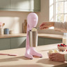Pink milkshake maker with stainless steel cup on kitchen counter, ice cream being scooped in