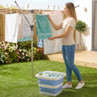 Foldable blue and white laundry basket in use by rotary washing line outdoors