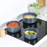Set of three blue speckled saucepans on a hob, each with different pasta dishes