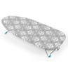 Grey ironing board with white geometric patterned cover, shown from side angle.