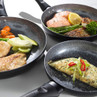 Set of three non-stick frying pans shown with cooked salmon, chicken, and an omelette.
