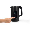 Black electric kettle with digital temperature display, showing a hand pressing the control panel.