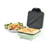 Light green sandwich toaster with two cooked toasties, plate of toasted sandwiches and salad