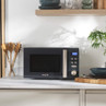 Grey microwave oven with digital display on kitchen worktop