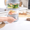 Electric food steamer with salmon and vegetables, hand turning timer dial