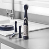 Electric cleaning brush set with four interchangeable heads on stand, navy and grey.