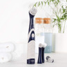 Electric cleaning brush with navy and white handle and three replacement heads on counter
