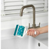 Blue pet hair remover roller being rinsed under tap in kitchen sink