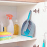 Blue and grey dustpan and brush set in cupboard with cleaning cloths and bottles