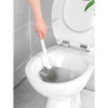Silicone toilet brush cleaning the inside of a white toilet bowl