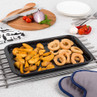 Tray of seasoned potato wedges and breaded onion rings on kitchen counter