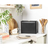 Black metal bread bin on kitchen worktop, shown in modern UK home setting