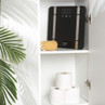 Black digital bathroom scale with silver accents on shelf beside bath sponge