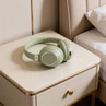 Green wireless over-ear headphones on bedside table