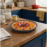 Non-stick fluted tart tin with a baked fruit tart, shown on a wooden kitchen worktop