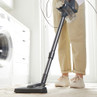 Corded handheld vacuum cleaner on beige carpet in modern laundry room