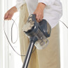 Corded handheld vacuum cleaner in use, shown from side view